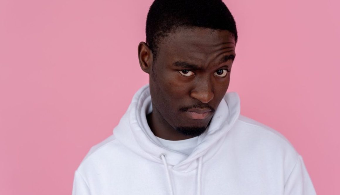 uncertain black man in hoodie in studio